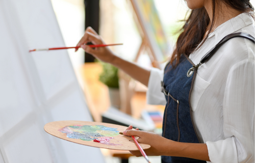 Mujer pintando un lienzo con un pincel