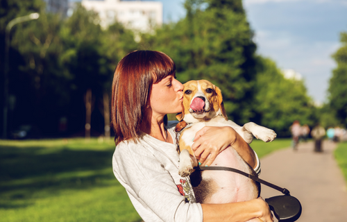Mujer abrazando y besando a su perro