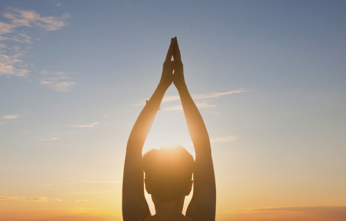 Mujer meditando en atardecer