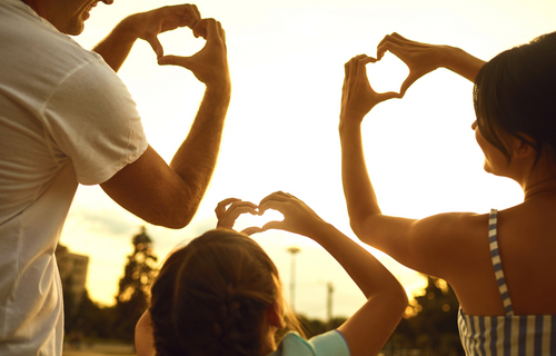 familia formando corazones con las manos