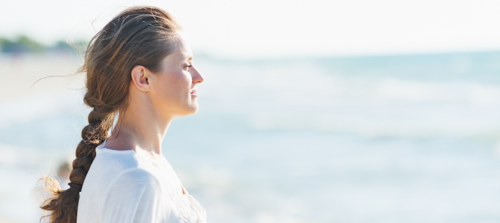 Mujer tranquila y en calma disfrutando la vista al mar